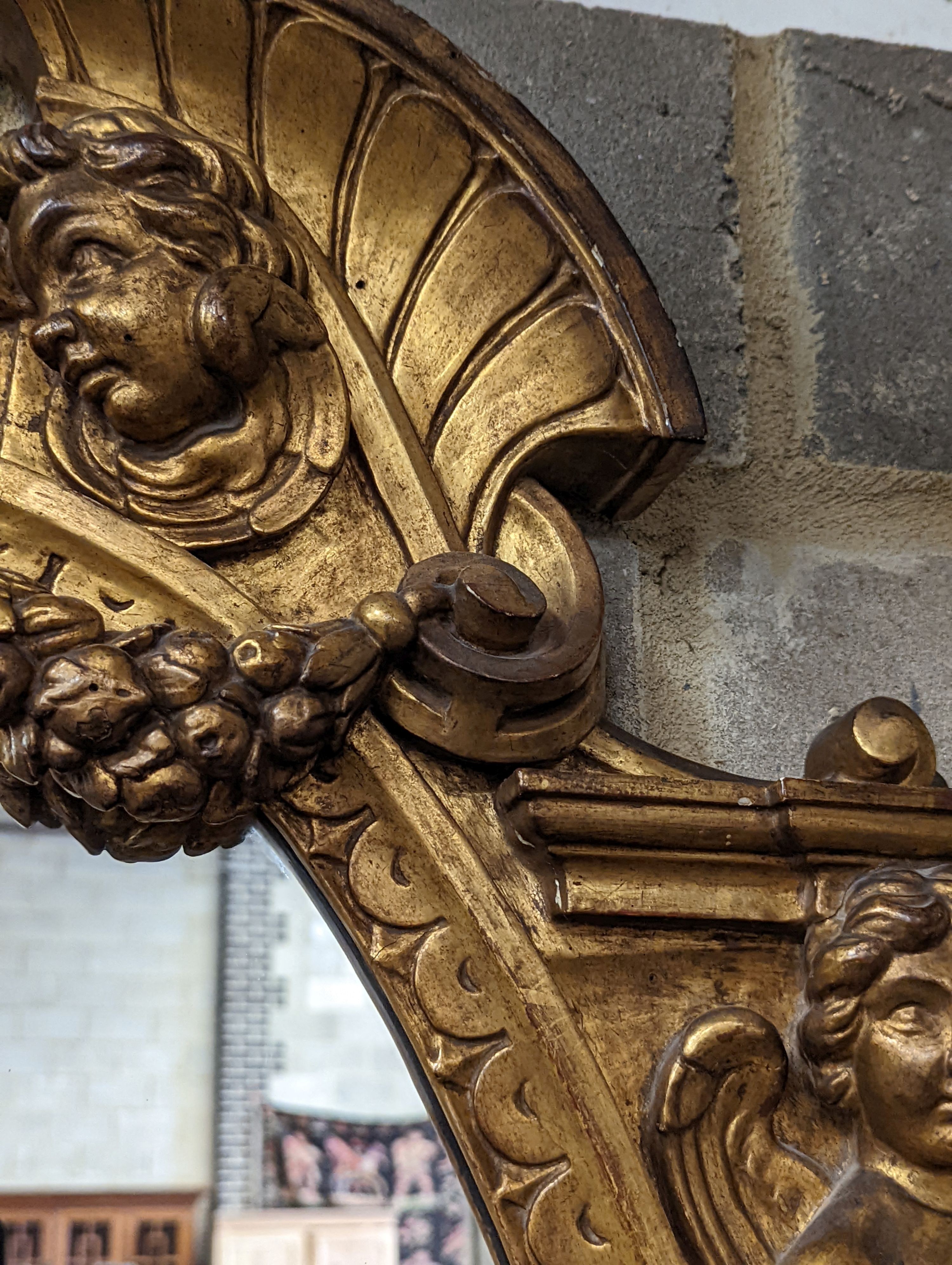 A Victorian carved giltwood oval wall mirror decorated with cherubs and C scrolls., width 74cm, height 110cm